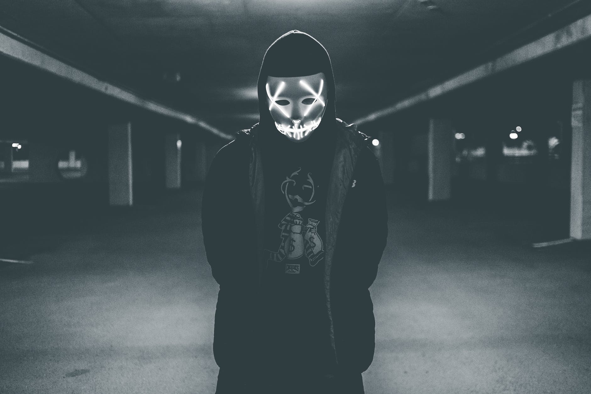 man wearing hood and mask with neon lights